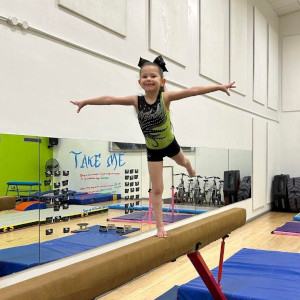 Girl performing an arabesque on beam